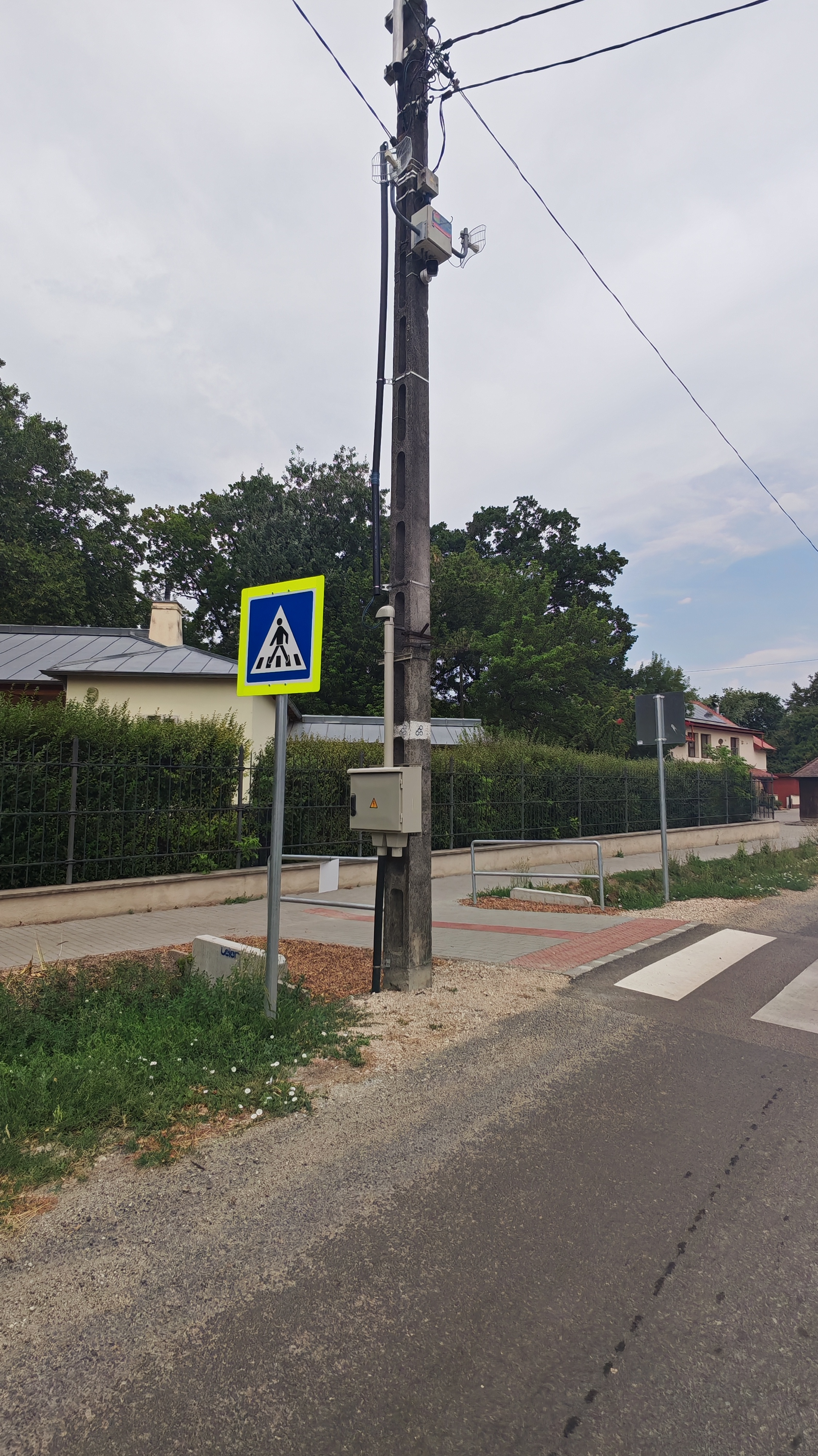 Közvilágítási oszlop kamerával és jelzőtáblával